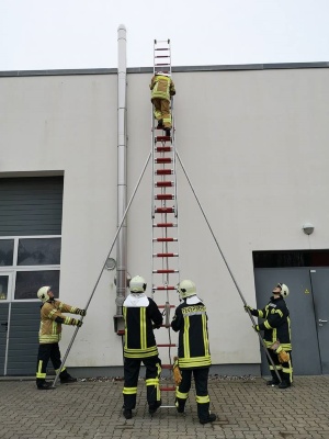 Leiter in Stellung bringen - Truppmann-Ausbildung © Feuerwehr Greifswald Feuerwehrmänner in Ausrüstung bringen eine Leiter in Stellung, um auf ein Häuserdach zu gelangen