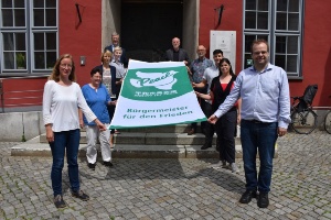 Flaggentag Mayor for Peace, Foto Pressestelle (3) © Pressestelle Dr. Fassbinder und Mitglieder der bürgerschaftlichen Gremien entrollen die Flagge