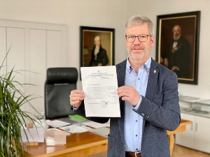 275157921_559683981753361_437531830432767123_n © Franziska Vopel Oberbürgermeister Dr. Stefan Fassbinder steht in seinem Büro und hält das Dankesschreiben aus Drohobytsch