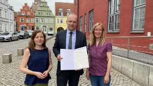 Charta der Vielfalt © Pressestelle der Universitäts- und Hansestadt Greifswald Anna Gatzke, Achim Lerm und Claudia Kowalzyck mit der Charta der Vielfalt vor dem Greifswalder Rathaus