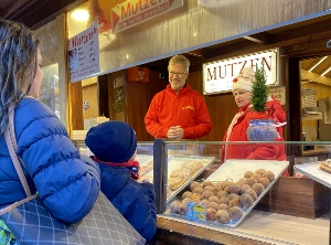 Dr. Fassbinder verkauft Mutzen auf dem Weihnachtsmarkt; Foto: Pressestelle © Foto: Pressestelle UHGW Dr. Fassbinder beim Verkauf von Mutzen auf dem Greifswalder Weihnachtsmarkt