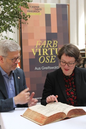 Taufeintrag von Caspar David Friedrich © Lea Muth Dr. Stefan Fassbinder und Anett Hauswald sehen sich den Taufeintrag von Caspar David Friedrich an
