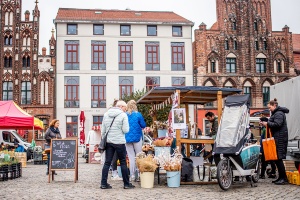 Regional- und Wochenmarkt © House of Pictures - S. Kohlhagen Ein Stand auf dem Regional- und Wochenmarkt, an dem verschiedene Marktbesucher Waren kaufen