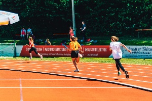 Tag des deutschen Sportabzeichens © Wally Pruß Drei Läuferinnen laufen im Volksstadion einen Staffellauf im Rahmen vom Tag des deutschen Sportabzeichens bei sonnigem Wetter