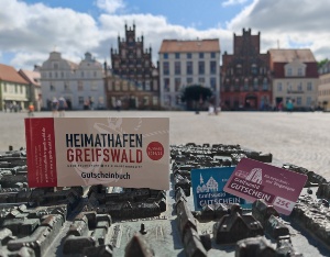 Das Gutscheinbuch auf der bronzenen Silhouette der Stadt auf dem Marktplatz 